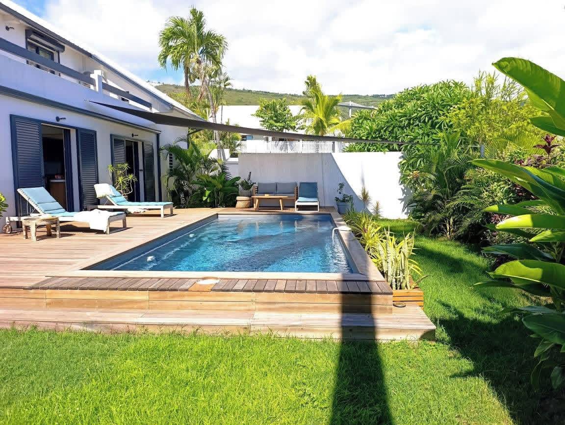 Piscine avec transats et jardin verdoyant
